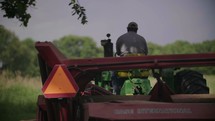 a farmer driving a bailing tractor 