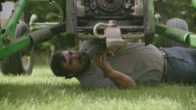 a farmer fixing a tractor 