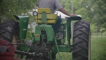 a farmer riding a bailing tractor 