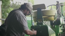 a farmer fixing a tractor 