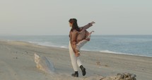 Girl dance on the beach near the ocean in summer
