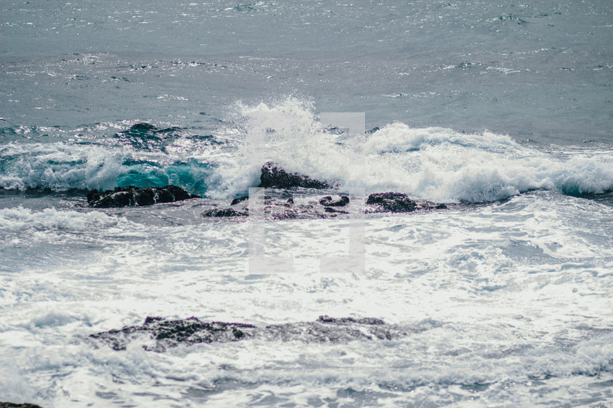 Ocean waves crashing upon rocks.