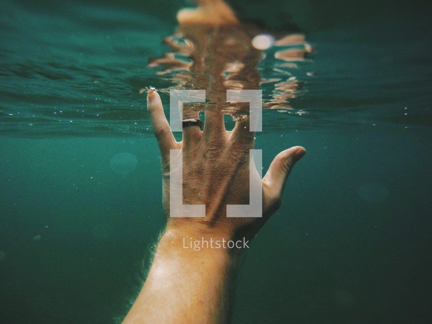 reaching hand under water 