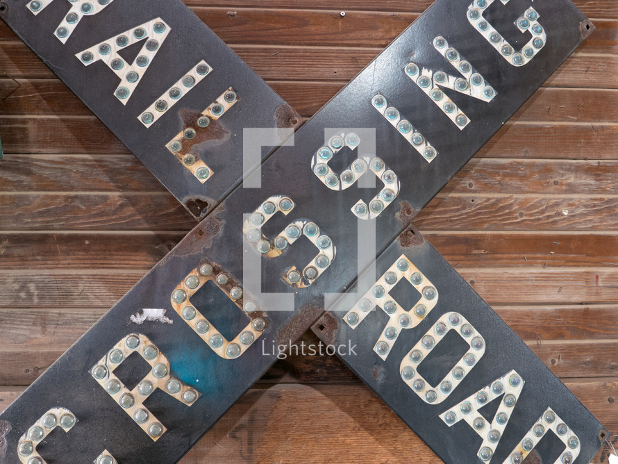 railroad crossing sign on display on wood board wall