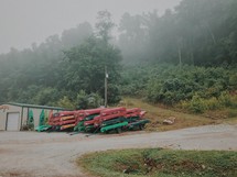 foggy sky and canoes and kayaks in storage 