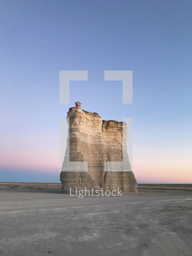 a rock formation in a desert at dusk 