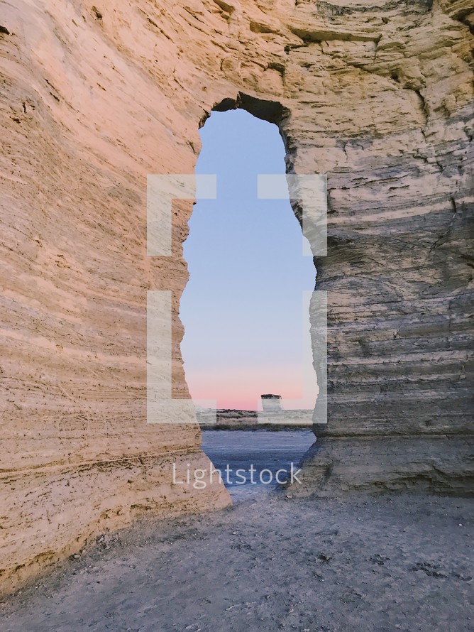 a rock formation in a desert at sunset 