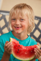 boy child eating a watermelon on a summer day