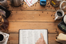 finger pointing to Bible scripture surrounded by coffee shop items 