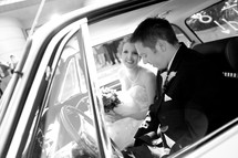 bride and groom sitting in their car