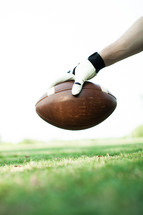 man holding a football above the field 
