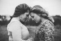 mother and daughter standing forehead to forehead