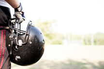 football player holding a helmet 