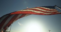 American flag blowing in light from sunset in slow motion.