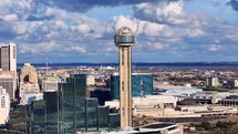 Panning aerial shot of Reunion Tower in Dallas Texas with blue sky and clouds in the background.	