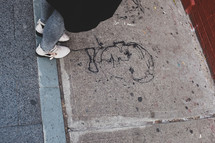 street art of a man's face on a city sidewalk 