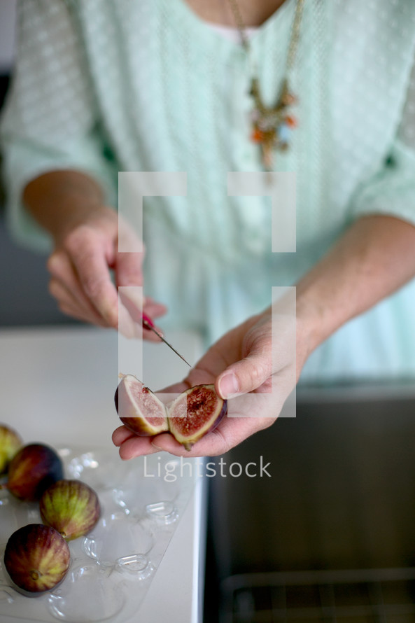 woman cutting fig with small knife 