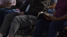 Men study their Bibles at a small group meeting