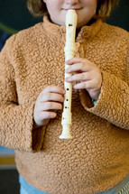 child playing  white recorder 