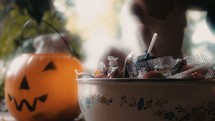 a child reaching for Halloween candy 