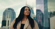 Young woman admiring downtown city buildings and scenery during sunset