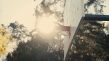 Close up of a basketball being shot on an outdoor basketball court on a sunny day