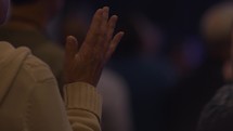 A woman raising her hand in praise during worship