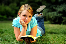 teen girl reading a Bible outdoors 