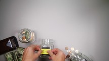 placing money in different jars 