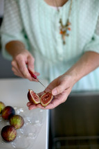 woman cutting fig with small knife 