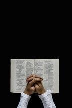 man praying over an open Bible 