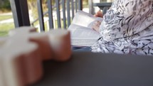 a woman reading a Bible on a porch swing 