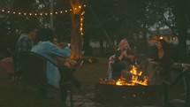 friends sitting around a campfire 