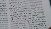 Close up of a Bible opened to 2 Timothy 3.