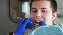 a dentist looking at a man's teeth 