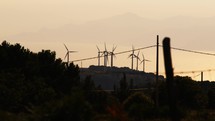 Silhouette of distant wind power plant generator on the mountains