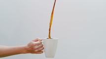 filling up a coffee cup with overflowing coffee