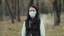 Young woman wearing protective medical face mask. Safe and happy woman practicing social distancing. Put on your respirator to protect the other people.