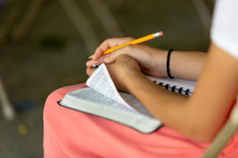 a teen girl sitting with a Bible on her lap 
