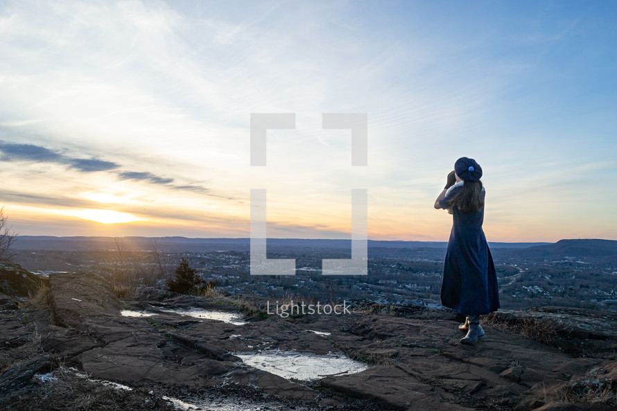 a woman standing on a mountaintop 
