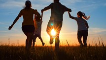 Silhouette happy family. Parents and little son fun at sunset. Silhouette family play at sunset. Teamwork child and parents fun in the park. Friendly family and kid dream concept.