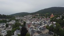 Aerial flyover of famous spa town Baden-Baden, Germany. Hilly landscape in background