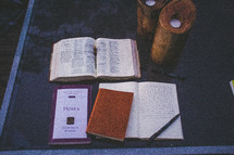 Open bible with the Book of Hosea and a journal on a glass table with candles.