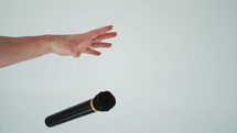 person dropping a microphone on a white background.
