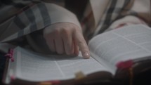 a young woman reading a Bible in her lap 