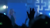 silhouettes of raised hands at a contemporary worship service 