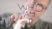 man writing the words who am I 