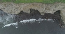 aerial view over a shoreline with breaking waves 