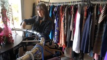 A woman shopping for clothes in a thrift store