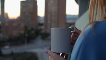 Woman holding warm mug in a city setting